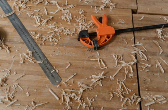 ruler and a clamp together on wooden planks